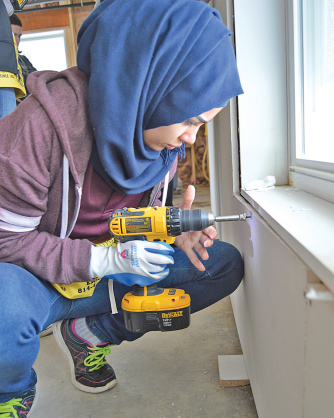Gannon sophomore Mariam Alkhafaji works on drywall <br />at the St. Joseph House